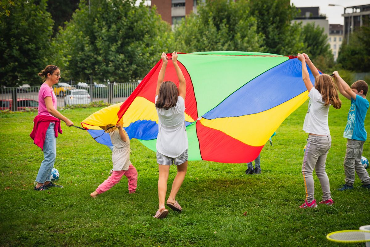 Kinder spielen mit farbigem Tuch